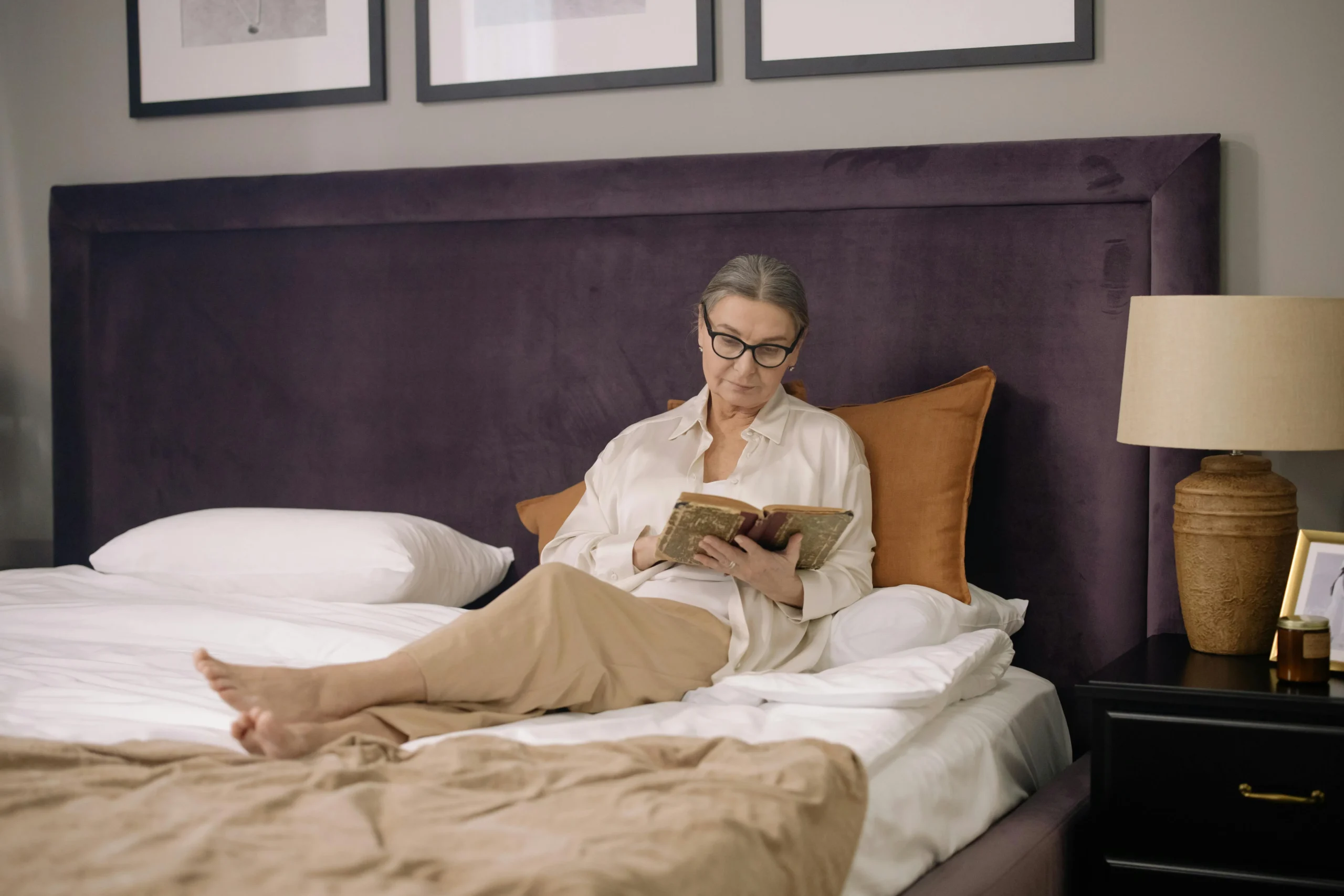 of_a_person_reading_a_book_by_soft_lamp_light_in_bed__Create_an_ultra_realistic_image_with_perfect_contrast_by_emphasizing_depth