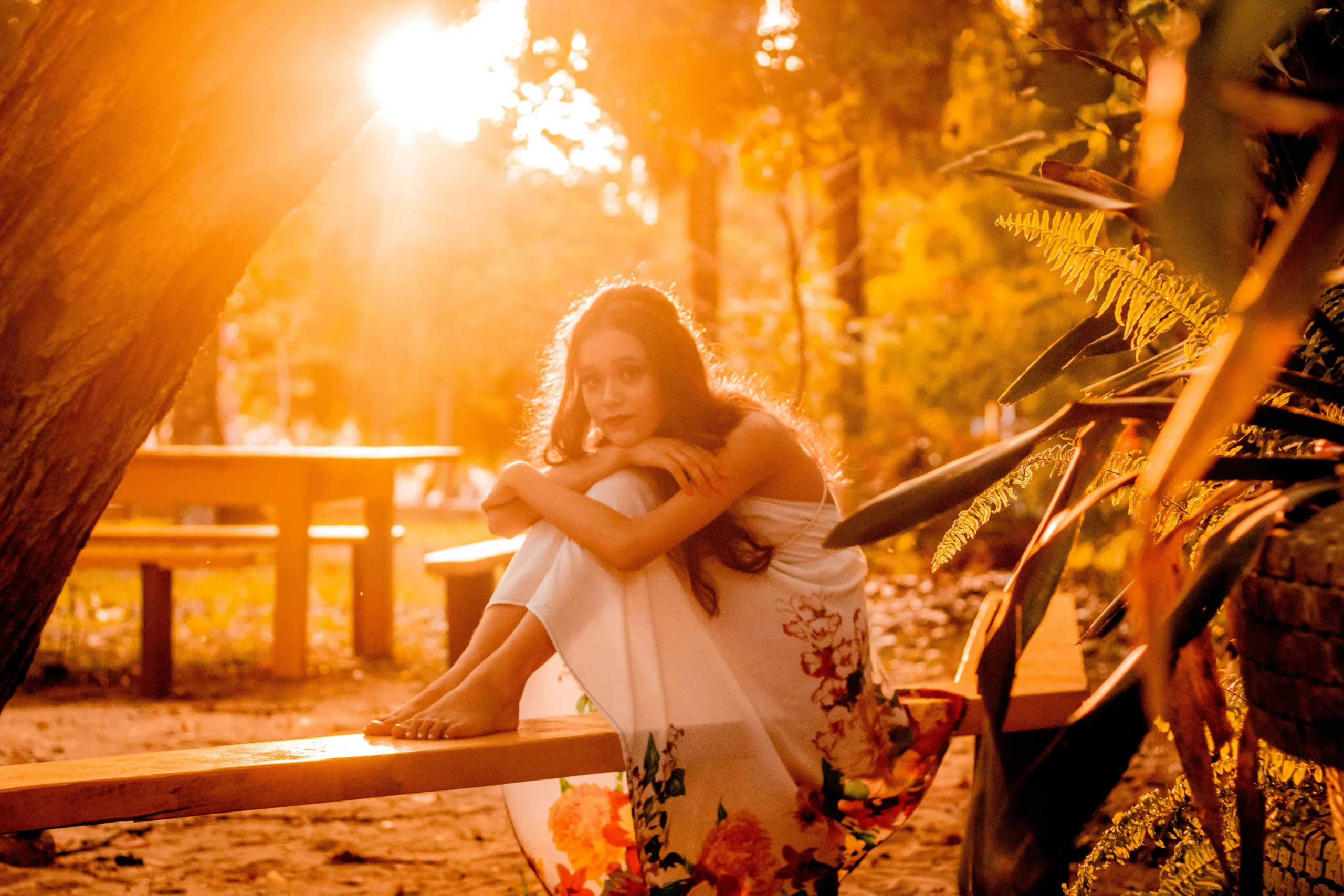 of_a_person_sitting_on_a_park_bench_surrounded_by_trees_and_flowers__Create_an_ultra_realistic_image_with_perfect_contrast_by_emphasizing_depth